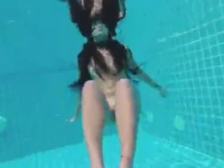 Teen with long hairs swim underwater in pool
