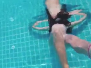 Teen with long hairs swim underwater in_pool