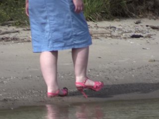 On High Heels_and Bare Feet on the Sand, Plump Legs Walk Along theShore.