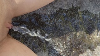 A Petite Girl Sits On A Rock To Pee