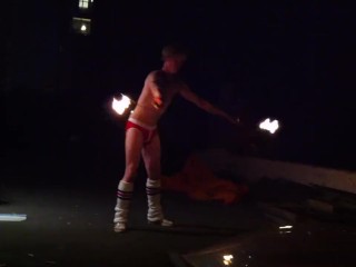 Blond guy spins fire on rooftop in socks and_underwear
