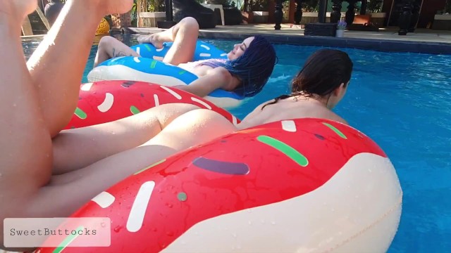 Две голые девушки дурачатся в бассейне