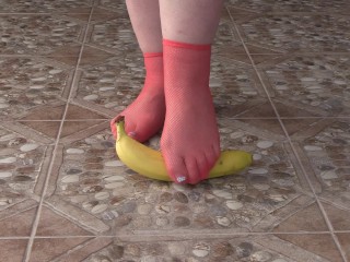 Fat legs in socks ruthlessly trample banana. Crush Fetish, foot fetish.