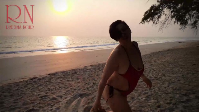 Bella signora alla solitaria spiaggia per nudisti. Costume da bagno rosso. Bikini rosso. Noce di co 15