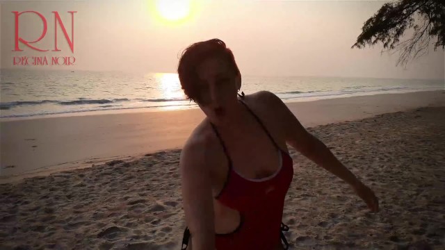Bella signora alla solitaria spiaggia per nudisti. Costume da bagno rosso. Bikini rosso. Noce di co 15