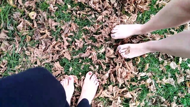 two sexy pairs of feet stepping on crunchy fall leaves