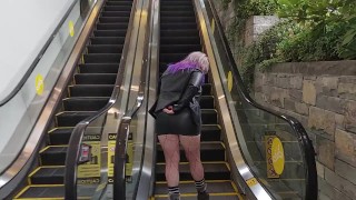 Milf in mini skirt rubs pussy on public escalator 