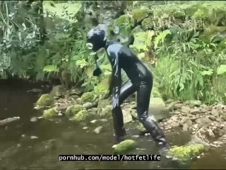 Outdoor walk in the wood and river bath full encased in black_latex catsuit and rubber_gas mask