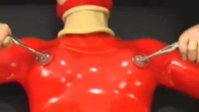 Sexy girl encased in red rubber catsuit loves medical games with mouth spreader and nipple clamps 15
