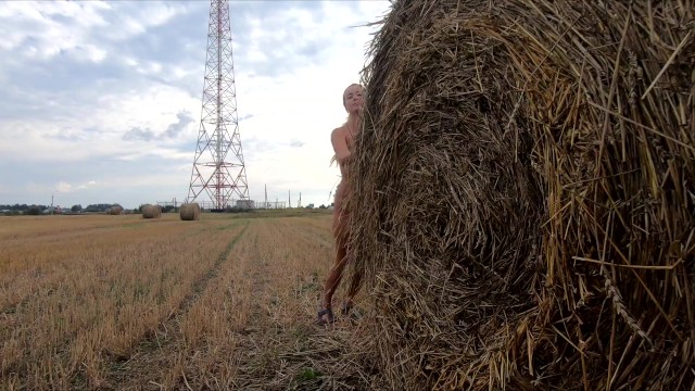 Naked girl playing with a bale of straw 8