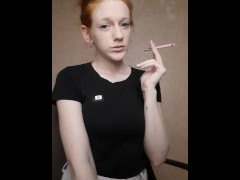 Redhead girl smokes a cigarette