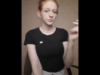 Redhead girl smokes a cigarette,hair isgathered in a bun