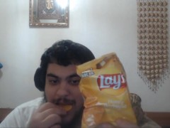 Eating 4 (four) lays honey BBQ flavored potato chips.