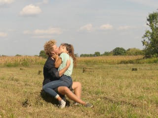 Beautiful Teen Couple in Love Passionately Kissing on thefield