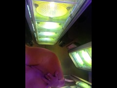 Heat from the tanning bed makes her hot and wetwet