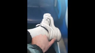 white socks and sneakers. a guy jerks off a dick through jeans in an empty train