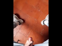 a guy in blue jeans and sneakers jerks off a dick and cums on the floor