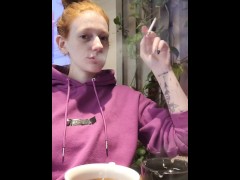 Redhead smokes in a cafe